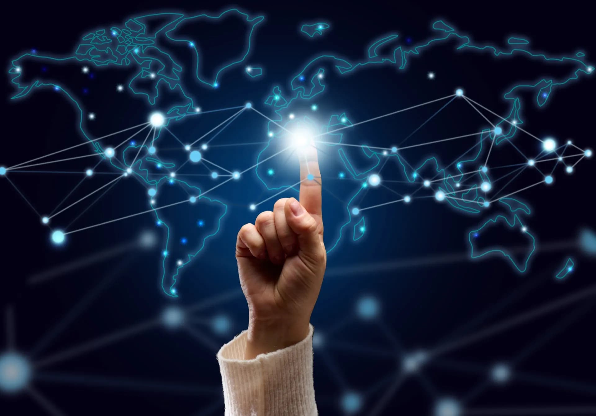 Una mano presiona un punto luminoso en un mapa mundial holográfico, con líneas que conectan nodos en todos los continentes